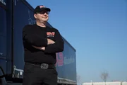 The truck driver enjoys the nice day.