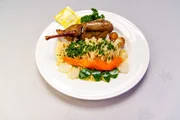 Die Hauptspeise: Gefüllte Tauben, Eierbandnundeln mit Zitronen-Thymian-Soße, Sommergemüse und Kartoffelbällchen.
