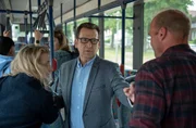 Lars Englen (Ingo Naujoks, M.) hat M&uuml;he, im fahrenden Bus f&uuml;r Ruhe und Ordnung zu sorgen (mit Kompars:innen).