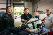 Wachmann Krause (Uli Krohm, 2.v.r.) wurde bei seinem Kontrollgang in einem Medikamentenlager niedergeschlagen. Während Dr. Haase (Fabian Harloff, 2.v.l.) sich um seinen Patienten kümmert erzählt Krohm Hans (Bruno F. Apitz, l.), dass die Täter nicht nur Medikamente, sondern auch seinen Wachhund Riffi gestohlen haben.