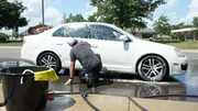 Dan McKernan washes down cars at a cow brush fundraiser for Barn Sanctuary. Dan McKernan washes down cars at a cow brush fundraiser for Barn Sanctuary.