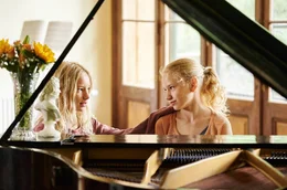 Lotte (Delphine Lohmann, rechts) spielt Luise (Mia Lohmann) auf dem Klavier vor.