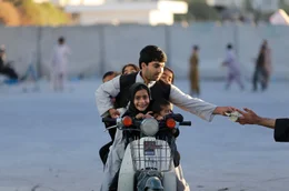 Kandahar, Afghanistan, 2013: Ein Vater bezahlt Eintritt f&uuml;r einen Vergn&uuml;gungspark.