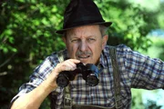 Schattenhofer (Werner Rom) hat sich auf die Lauer gelegt, um den Nudisten am Lansinger Weiher auf frischer Tat zu ertappen.