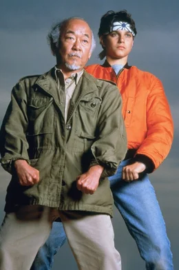 Nach ihrer R&uuml;ckkehr aus Okinawa planen Daniel (Ralph Macchio, r.) und sein Freund und Lehrmeister Mr. Miyagi (Noriyuki "Pat" Morita, l.) die Er&ouml;ffnung eines Bonsaigesch&auml;ftes.