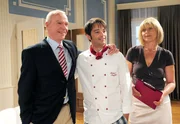 Robert (Lorenzo Patané, M.) hält zu seinem Vater Werner (Dirk Galuba, l., mit Mona Seefried, r.), was die Rückgewinnung der Hotelanteile anbelangt.