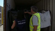 The customs officer inspects the contents of the container.
