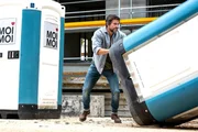 Mischko (Tom Beck) wirft das Dixi-Klo, in dem Korbinian (Max Woelky, nicht im Bild) sitzt.