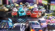 Hook (Mi., t&uuml;rkis) und Lightning McQueen (Mi., rot) nehmen an einem Autorennen in Tokio teil.