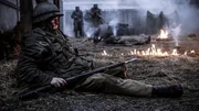 (Dramatische Nachstellung) Ein US-Soldat liegt verletzt und bewegungsunfähig da, während deutsche Soldaten anrücken. (Dramatische Nachstellung) Ein US-Soldat liegt verletzt und bewegungsunfähig da, während deutsche Soldaten anrücken.