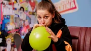 Marina checkt, wie viele Atemzüge sie benötigt, um einen Luftballon aufzupusten.