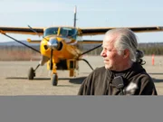 Stan Zuray standing next to a yellow plane.