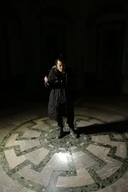 WEWELSBURG CASTLE, GERMANY - Robert Joe shines a light on the "Black Sun" symbol as he explores the Supreme Leaders' Hall in the dark.
