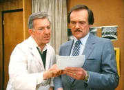 Quincy (Jack Klugman, li.) will Dr. Asten (John S. Ragin) beweisen, daß er reingelegt worden ist.
