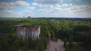 Die Sperrzone um das Atomkraftwerk Tschernobyl. Im Vordergrund die verlassene Stadt Pripyat, im Hintergrund der Ungl&uuml;cksreaktor von Tschernobyl.