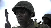 Der Gefreite Henry Parham (gespielt von Ishmel Bridgeman) wartet in einer Szene einer historischen Nachstellung des Zweiten Weltkriegs für "Erased" auf seine Landung am Omaha Beach: WW2's Heroes of Color". Private Parham diente mit dem 320th Barrage Balloon Battalion am D-Day.