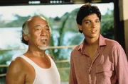 Daniel-san (Ralph Macchio, r.) begleitet Mister Miyagi (Pat Morita, l.) auf eine Reise zur&uuml;ck in seine Heimat Okinawa. Doch ein ungekl&auml;rter Konflikt aus seiner Vergangenheit sucht Mister Miyagi heim.