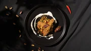 Klassischer tunesischer Salat aus gegrilltem Gemüse und dazu werden zarte Lammfilets mit Knusperpanade aus Pistazien serviert.