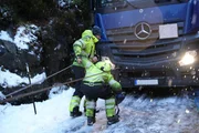 Thord and Eirik connect winch wires to the front of the truck. (National Geographic) Thord and Eirik connect winch wires to the front of the truck. (National Geographic)