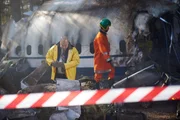 KAIB-Ermittler (gespielt von Daniel Park und Hintergrunddarstellern) untersuchen das Wrack von Air China Flug 129. KAIB-Ermittler (gespielt von Daniel Park und Hintergrunddarstellern) untersuchen das Wrack von Air China Flug 129.