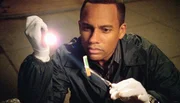 Ein Mann ist in einem brennenden Zigarettenkost&uuml;m von einem Geb&auml;ude gest&uuml;rzt: Dr. Hawkes (Hill Harper) untersucht den Vorfall.