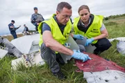 Brantford, Ontario - Die Ermittlungsassistentin (gespielt von Emily Andrews) und der Ermittler Ron Smits (gespielt von Jeff Miller) suchen an der Absturzstelle des Malaysian Airlines-Fluges 17 nach Beweisen im Wrack, während DPR-Soldaten (gespielt von Nicolas Rhind und Hintergrunddarstellern) die Absturzstelle bewachen.
