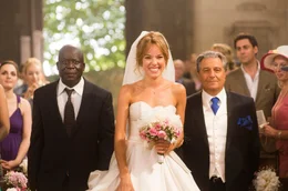 Claude (Christian Clavier) und Charles Vater Andr&eacute; (Pascal N&rsquo;Zonzi) f&uuml;hren Laure (&Eacute;lodie Fontan) zum Altar.