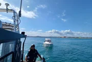 Ein Patrouillenboot der Guardia Civil schleppt ein treibendes Sportboot in Gerona, Katalonien, Spanien.