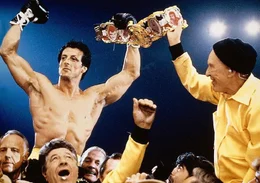 Zehnmal hat Rocky (Sylvester Stallone) seinen Titel im Ring erfolgreich verteidigt, aber nur deshalb, weil ihm weil sein Trainer Trainers Mickey (Burgess Meredith,r.) nur leicht zu schlagende Gegner ausgesucht hat. Doch das endet j&auml;h.