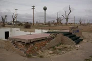 The foundations of a destroyed home in Greensburg Kansas. In the background is the town water tower.