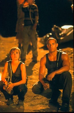 Der interstellare Frachter Hunter Gratzner muss eine Notlandung auf einem unbekannten Planeten aus&uuml;ben. Um zu &Uuml;berleben m&uuml;ssen Andockpilotin Carolyn Fry (Radha Mitchell, l.) und der Schwerverbrecher Richard B. Riddick (Vin Diesel, r.) zusammenarbeiten.