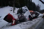 A new gritter truck slid on ice and is on it's side in the ditch.