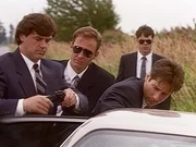 Der FBI-Agent Fox Mulder (David Duchovny, r.) wird vom militärischen Sicherheitsdienst unsanft aufgefordert, das Gelände von Ellens Airbase umgehend zu verlassen.