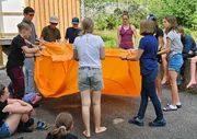 Erstes Survival-Training: Auf dem Schulgelände erklärt Tutorin Karo den Jugendlichen, wie man ein Group Shelter, das Notzelt für unterwegs, richtig einsetzt.