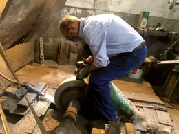Hubert Winkler Kunstschmied, Pfarrwerfen beim Schleifen am Schleifstein (Axt).