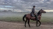 Ein Mann reitet auf einem Pferd.