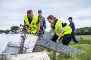 Die Ermittlungsassistentin (gespielt von Emily Andrews) und der Ermittler Ron Smits (gespielt von Jeff Miller) suchen an der Absturzstelle des Malaysian Airlines-Fluges 17 nach Beweisen im Wrack, während DPR-Soldaten die Absturzstelle bewachen.