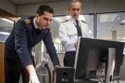 Admiral Shaw (Stephen Dillane, r.) bemüht sich, die "Vigil" zu orten. (Darsteller links nicht bekannt.)