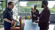 Aaron Abrabanel (Eelco Smits, li.) macht blutige Geschäfte mit dem Diplomaten Musa Bekele (Lolu Ajayi, re.) unter Aufsicht seines Bodyguards Lansana Alhadi (Joe Sinduhije, Mitte).