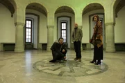 WEWELSBURG CASTLE, GERMANY - Robert Joe, Sam Willis, and Dr. Eva Kingsepp stand on the Black Sun symbol in the Supreme Leaders' Hall at Wewelsburg Castle. The Black Sun has spawned myths about secret Nazi rituals that went on behind the castle's walls. (photo credit: FIC Singapore/Rob Taylor)