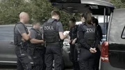 Beamte von Zoll und Polizei bereiten sich auf eine Razzia vor.