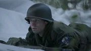 REENACTMENT - Private First Class Melvin Biddle kriecht durch den Schnee, während über ihm die Kugeln der Feinde fliegen. (Holdout II Productions Inc.)
