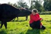 Marisa Marquardt auf der Weide mit einem neugierigen Wagyu-Rind.