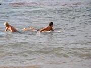 Two surfers on boards, bloody water.