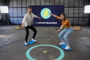 Das Moderatorenteam Laura und Stefan machen Trockenübungen für's Windsurfen, um ihre Balance zu trainieren. Keine leichte Aufgabe!