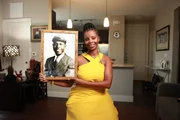 Erika Bethea hält ein Porträt ihres Großvaters, Clark Simmons, in ihrem Haus in Plano, Texas. "Erased: WW2's Heroes of Color" erzählt die Geschichten dreier schwarzer Helden, die wie durch ein Wunder den Angriff auf Pearl Harbor überlebten. Einer dieser Männer war Clark Simmons, der als Messdiener auf der USS Utah diente. (National Geographic/Nelson Adeosun)