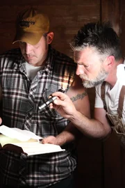 FULTON, MS, USA: Jay and Mark are looking at a handwritten note found inside an old book. FULTON, MS, USA: Jay and Mark are looking at a handwritten note found inside an old book.