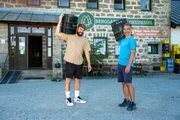 Marcus Fahn (rechts) und Philipp Schmöller stehen zusammen mit Bierfässern auf den Schultern vor dem Berggasthof Dreisessel. Marcus Fahn (rechts) und Philipp Schmöller stehen zusammen mit Bierfässern auf den Schultern vor dem Berggasthof Dreisessel.