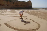 Die Algarve. Schroffe Klippen, sanfte Lagunen. Der Sandmaler Vitor Raposo nutzt die Strände der Algarve. Die Algarve. Schroffe Klippen, sanfte Lagunen. Der Sandmaler Vitor Raposo nutzt die Strände der Algarve.