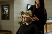 Joleen Cummings frisiert die Haare einer Kundin. (Szene nachgestellt)
